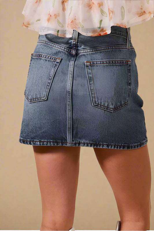 Denim skirt worn by a person on a beige background