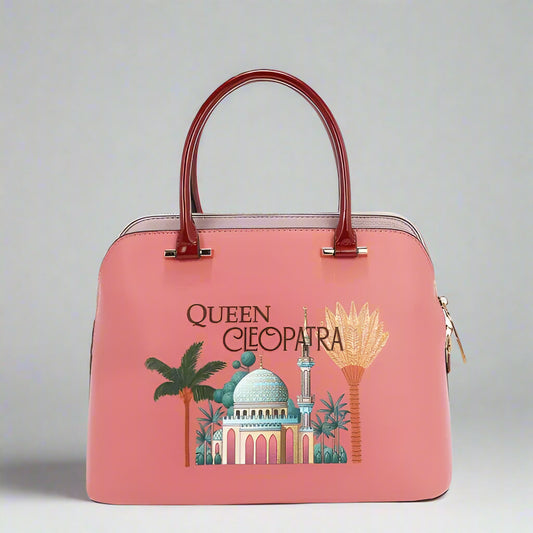 Pink handbag with 'Queen Cleopatra' design on a white background