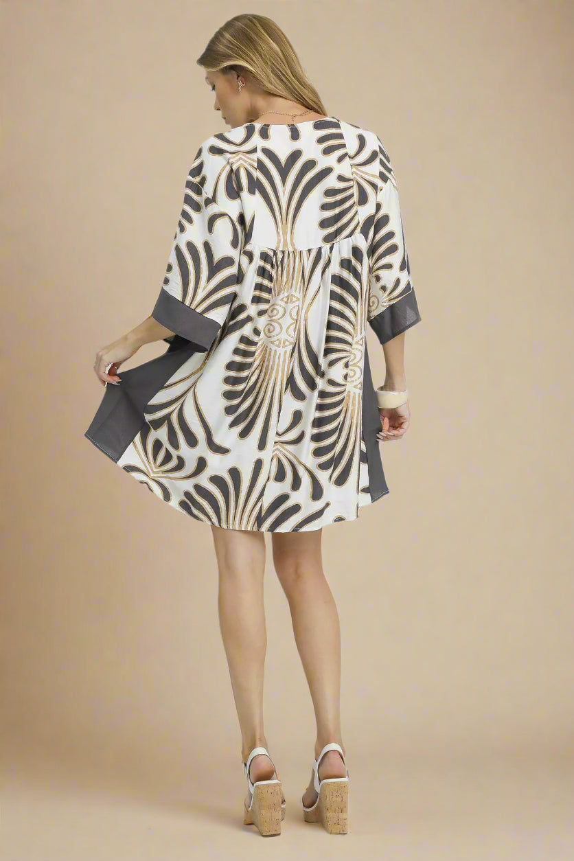 Woman wearing a patterned dress with a plain background