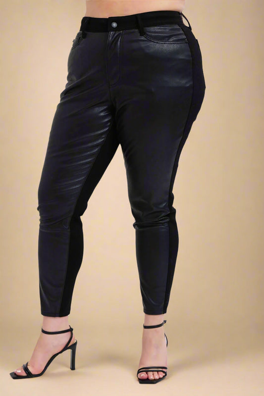 Black leather pants worn by a person on a white background