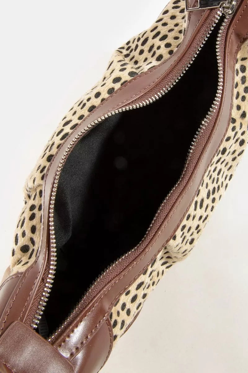 Leopard print clutch bag with a brown interior on a light beige background