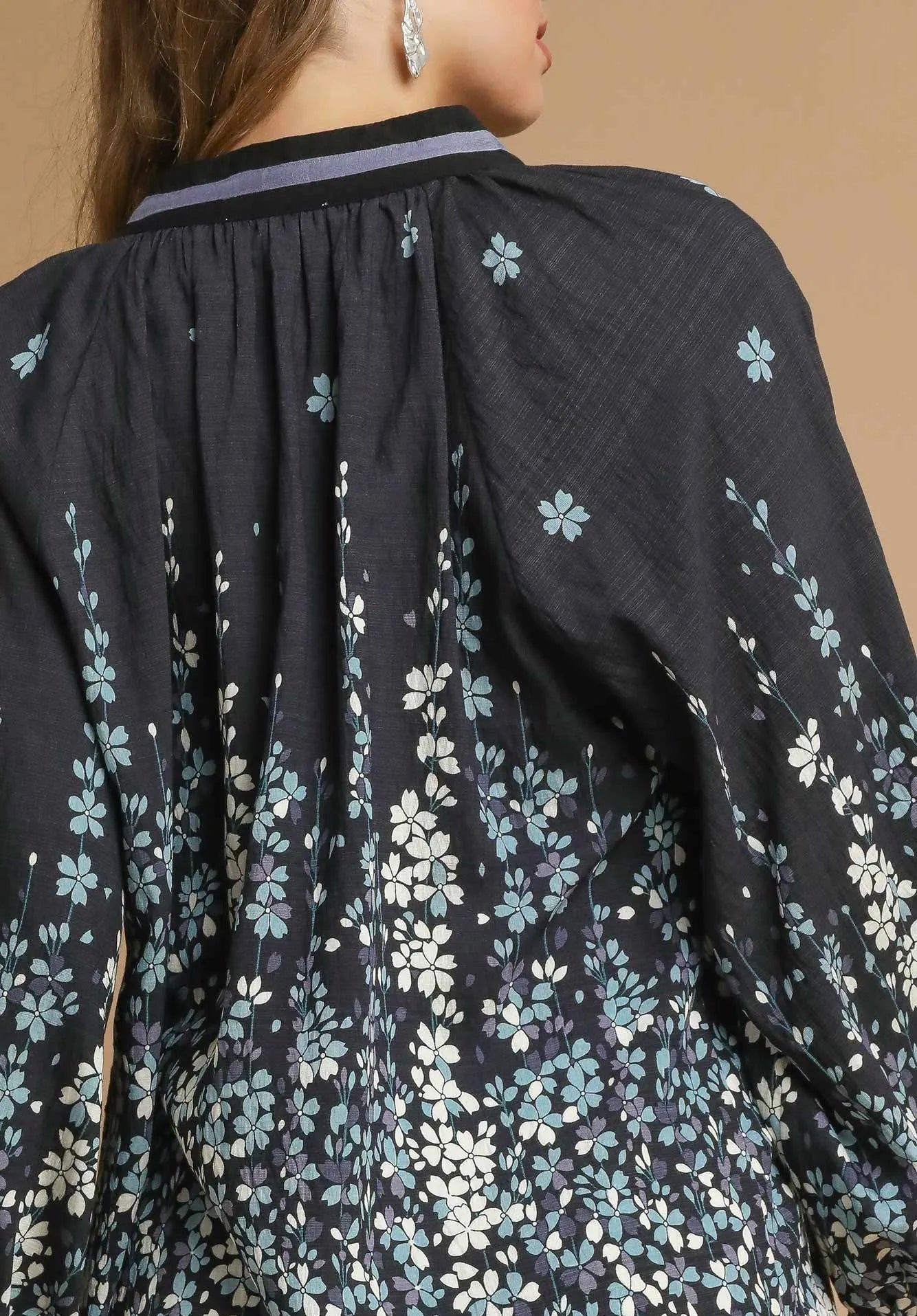 Black floral-patterned garment with a close-up of the fabric texture.