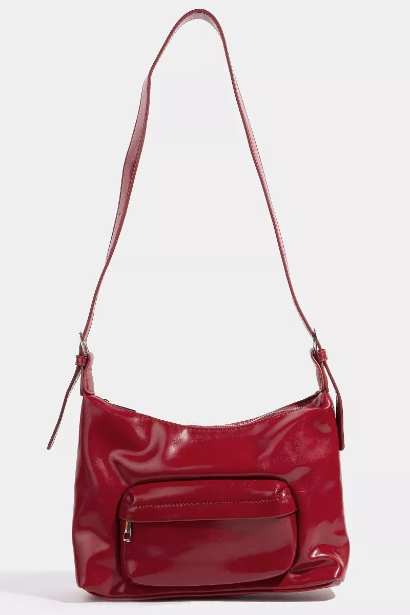 Red handbag with a strap on a white background