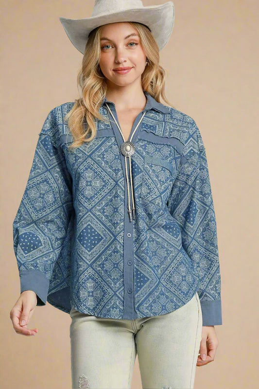 Woman wearing a blue patterned shirt with a silver tassel and a white cowboy hat on a beige background