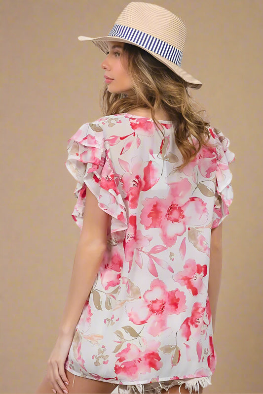 Woman wearing a floral dress and straw hat against a white background