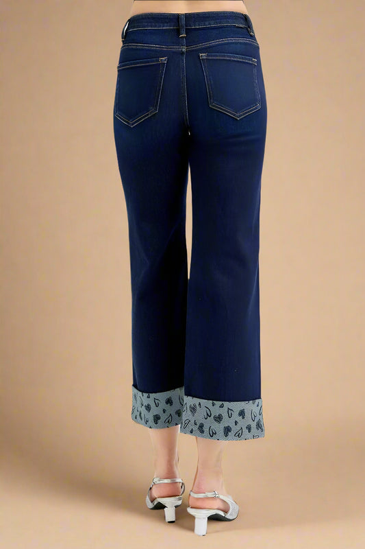 Blue jeans with patterned cuffs on a white background