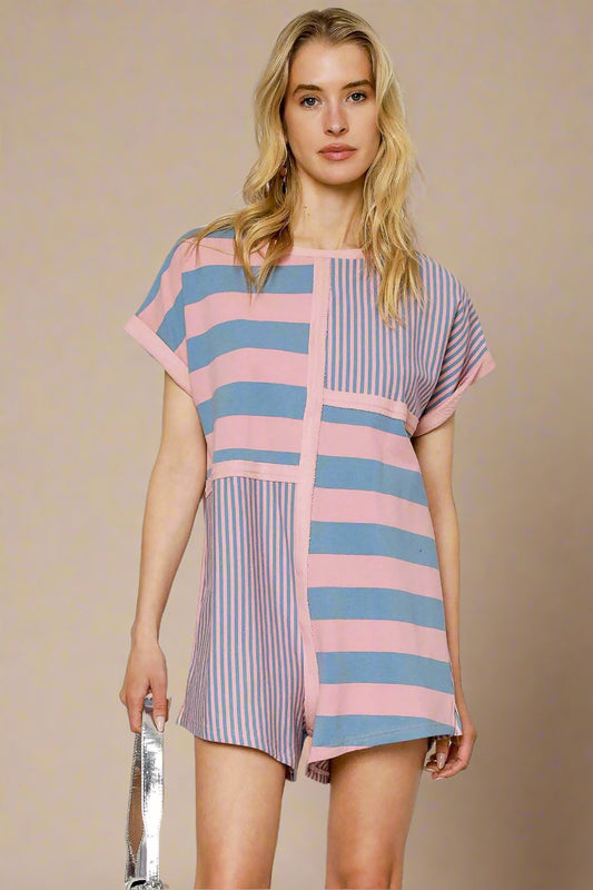 Woman wearing a colorful striped romper on a white background