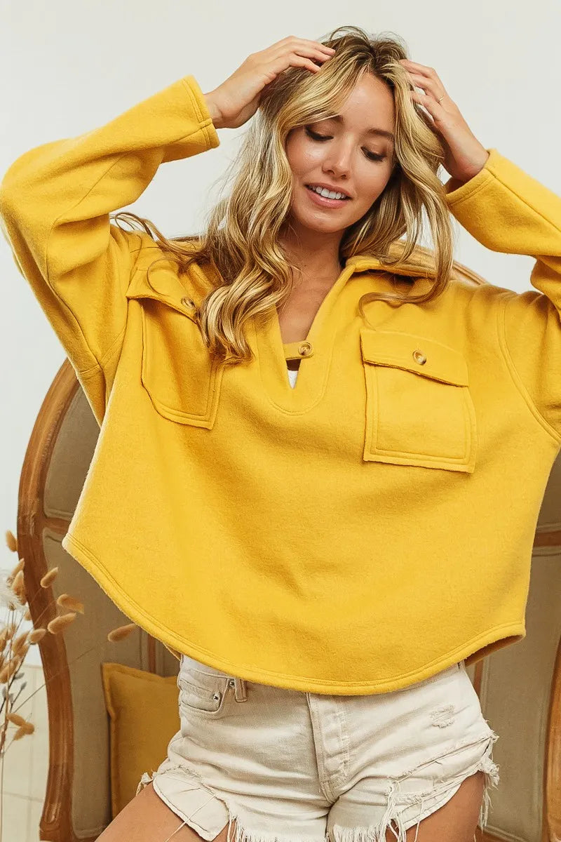 Woman wearing a yellow oversized shirt with a neutral background