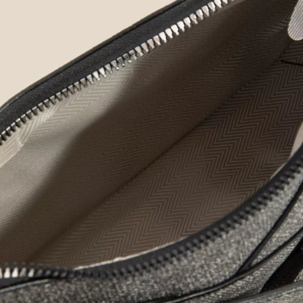 Close-up of a textured gray bag interior with a zipper.