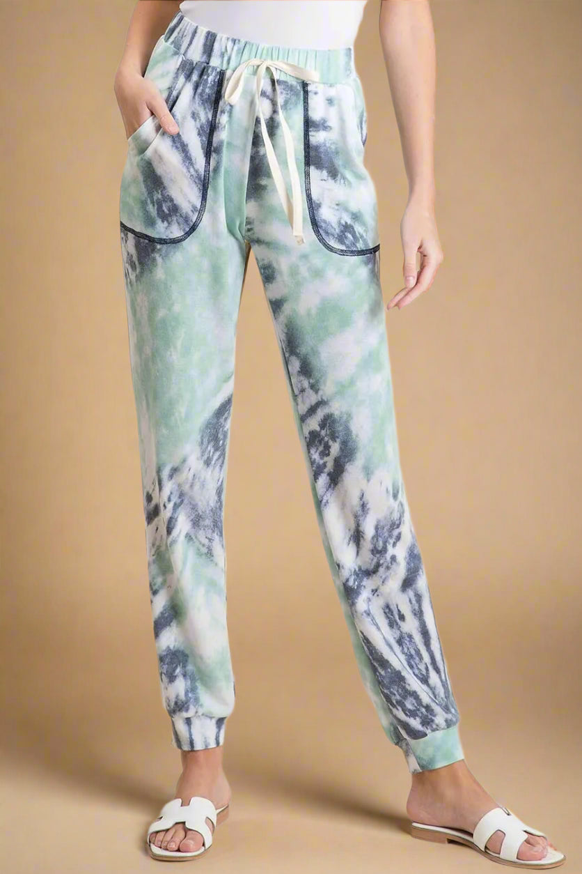 Tie-dye jogger pants worn by a person on a beige background
