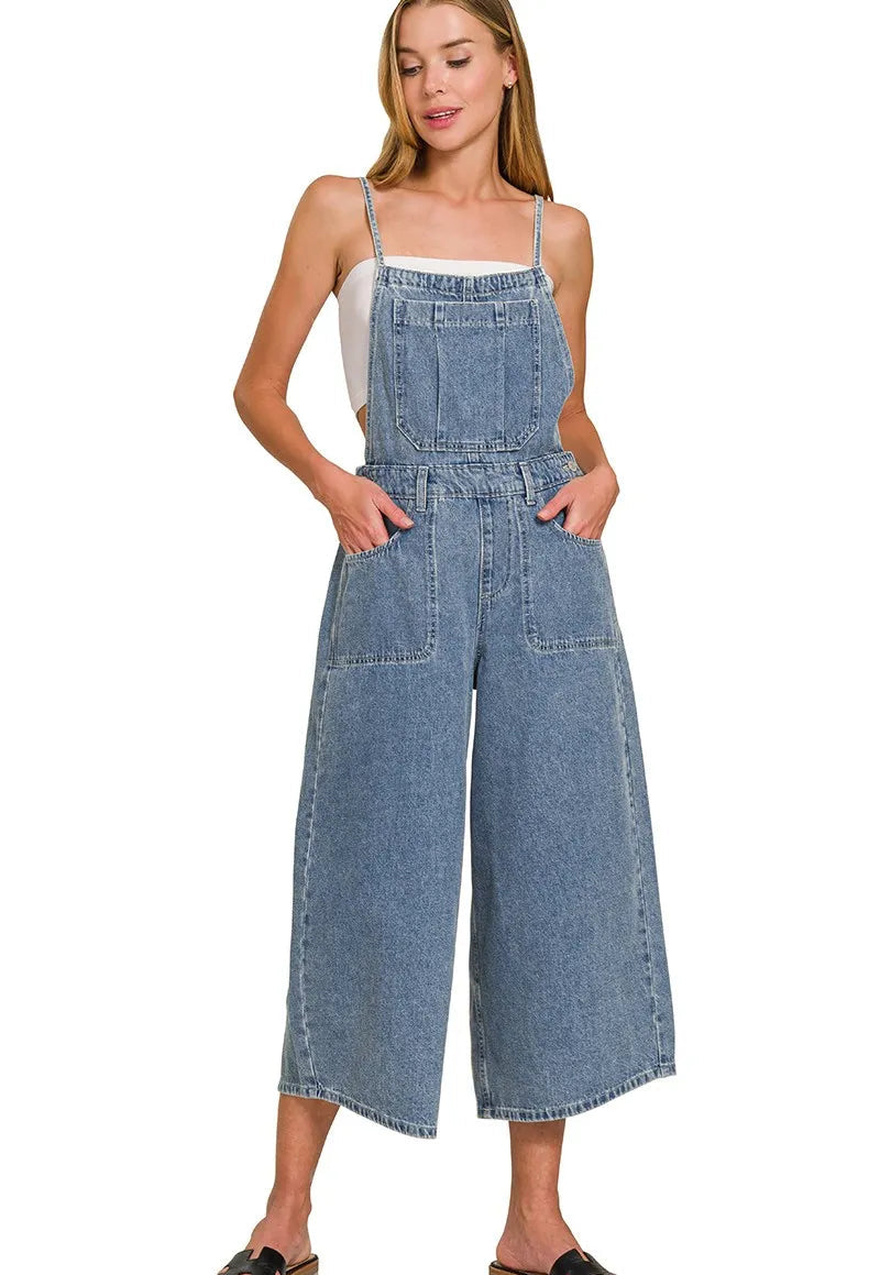 Woman wearing a denim jumpsuit on a white background
