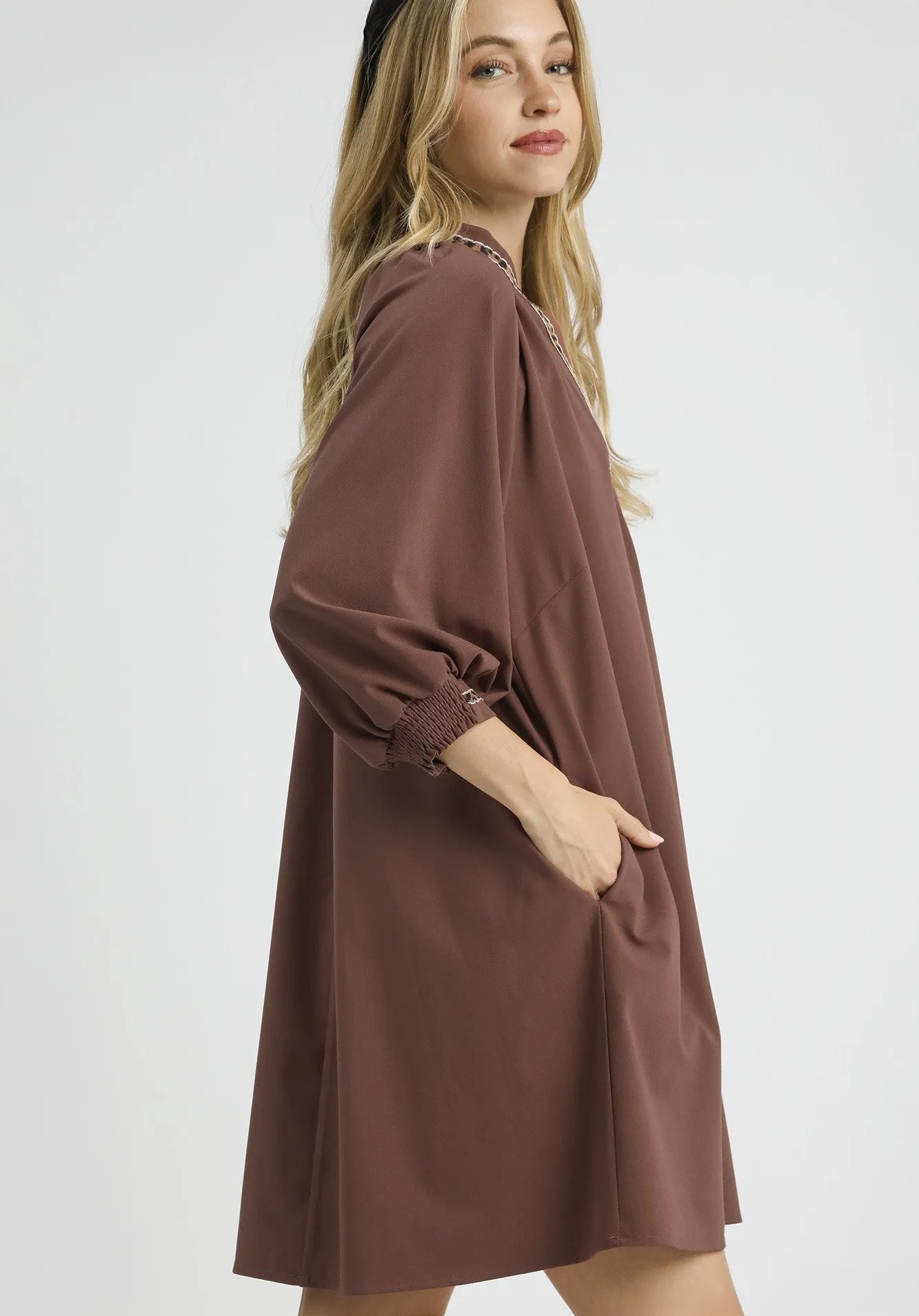 Woman wearing a brown dress on a white background