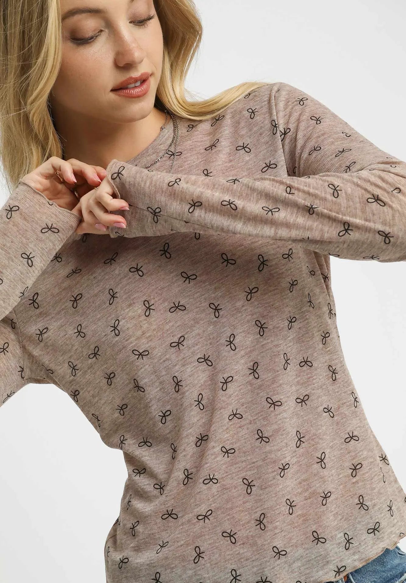 Woman wearing a brown long-sleeve top with black pattern on a white background