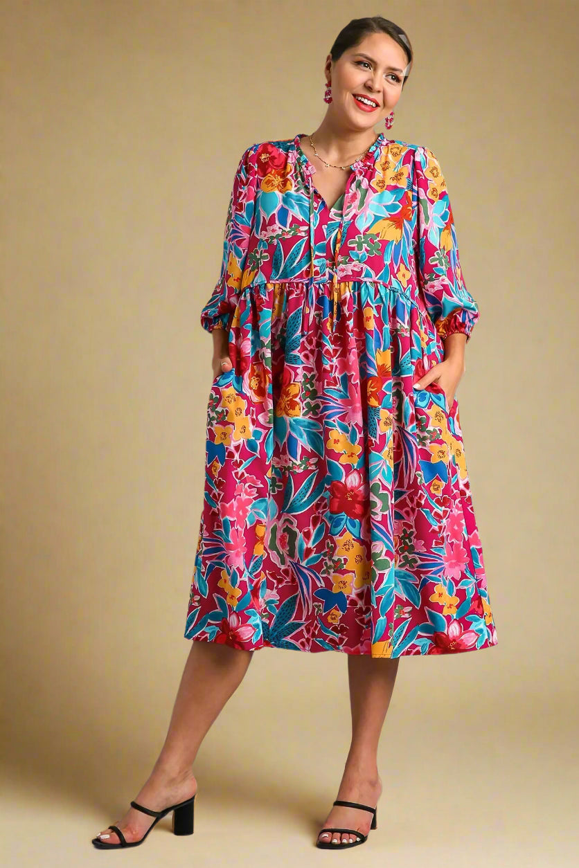 Woman wearing a colorful floral dress on a beige background
