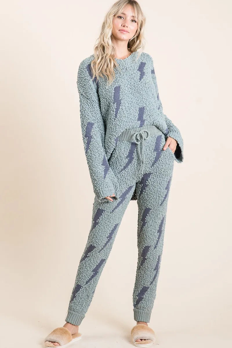Woman wearing a blue patterned loungewear set on a beige background