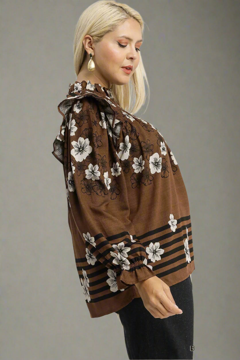 Woman wearing a brown floral blouse with a plain background