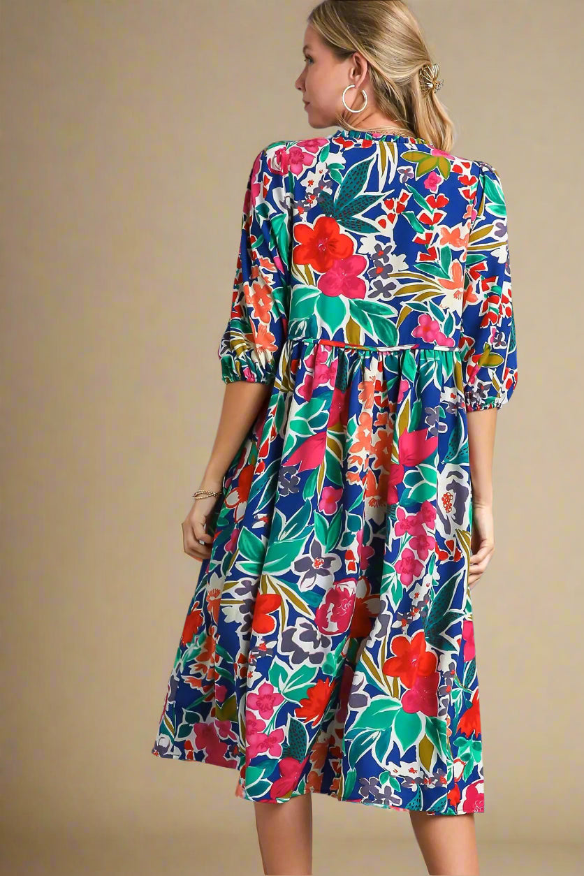 Woman wearing a colorful floral dress on a beige background
