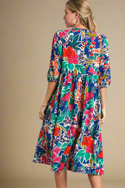 Woman wearing a colorful floral dress on a beige background