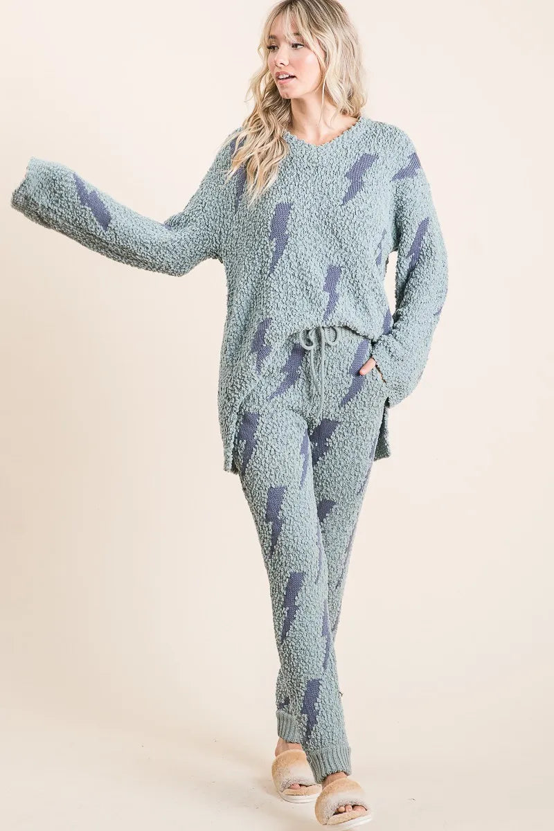 Woman wearing a blue patterned loungewear set on a beige background