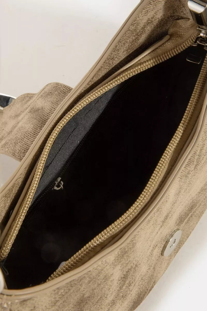 Close-up of a beige handbag with a visible brand logo on a light background