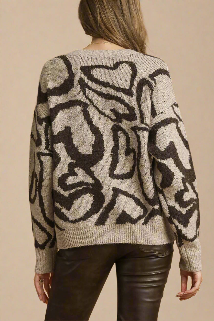 Person wearing a patterned sweater with a neutral background