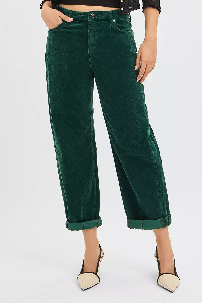 Person wearing green velvet pants on a white background
