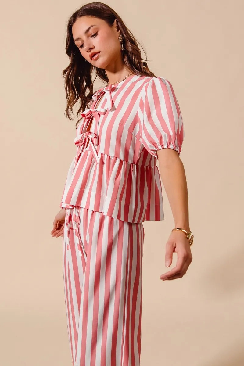 Woman wearing a red and white striped outfit on a beige background
