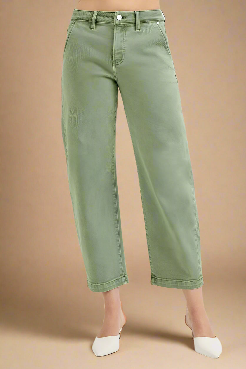 Green jeans worn by a person on a beige background