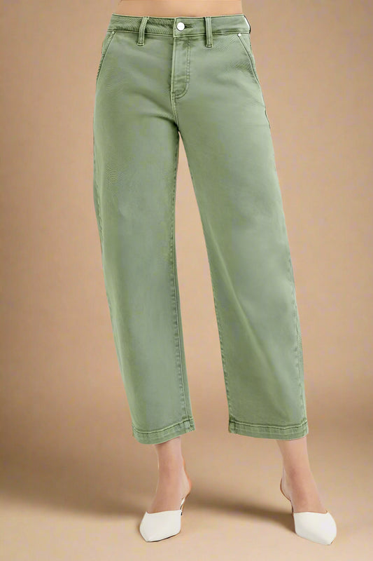 Green jeans worn by a person on a beige background