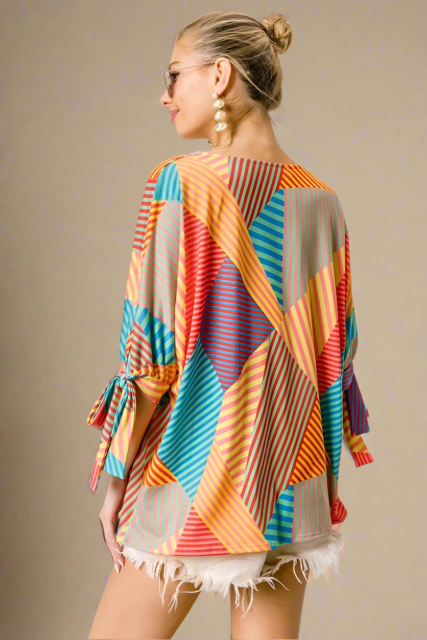 Woman wearing a colorful patterned top with a beige background