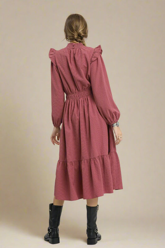 Dusty rose dress worn by a person on a beige background