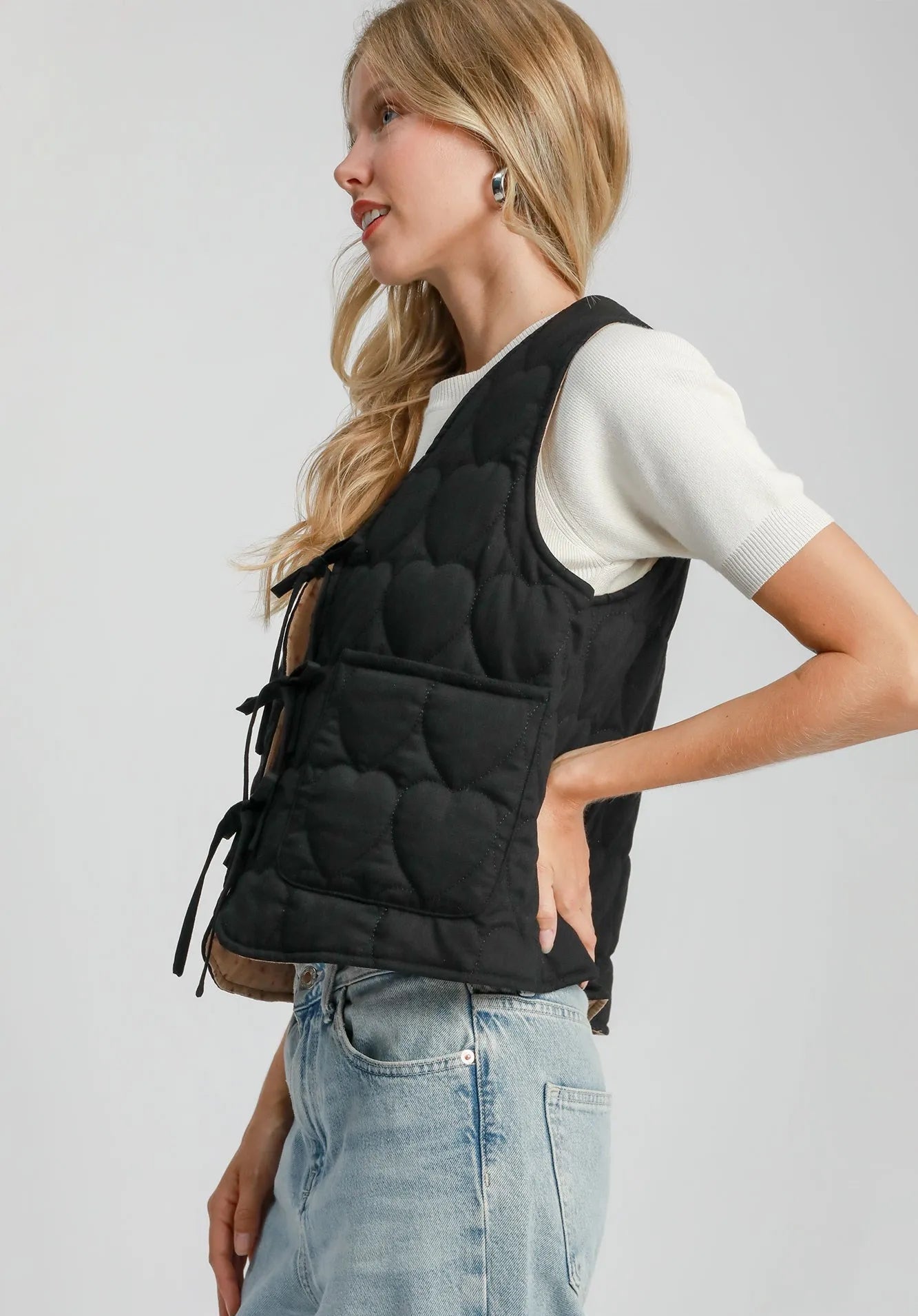 Woman wearing a black puffer vest on a gray background