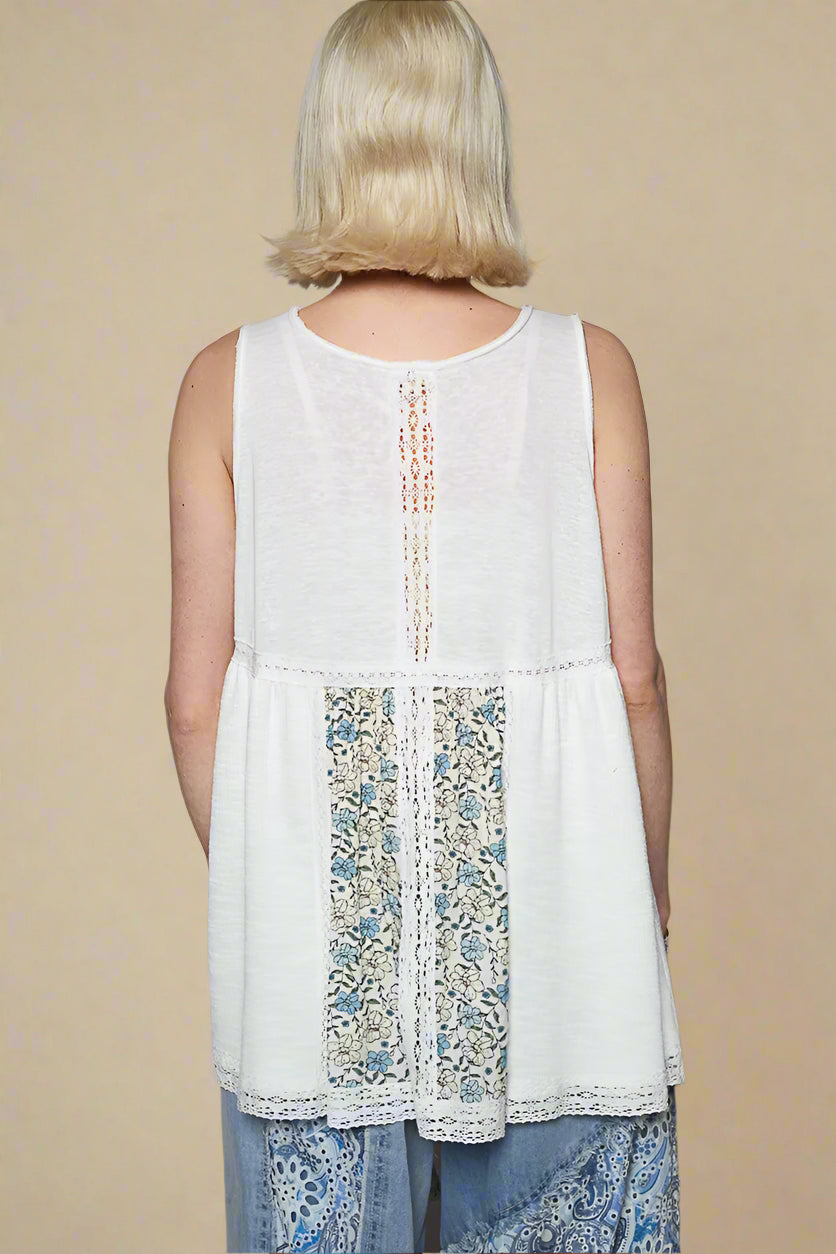 White sleeveless top with floral pattern on a plain background