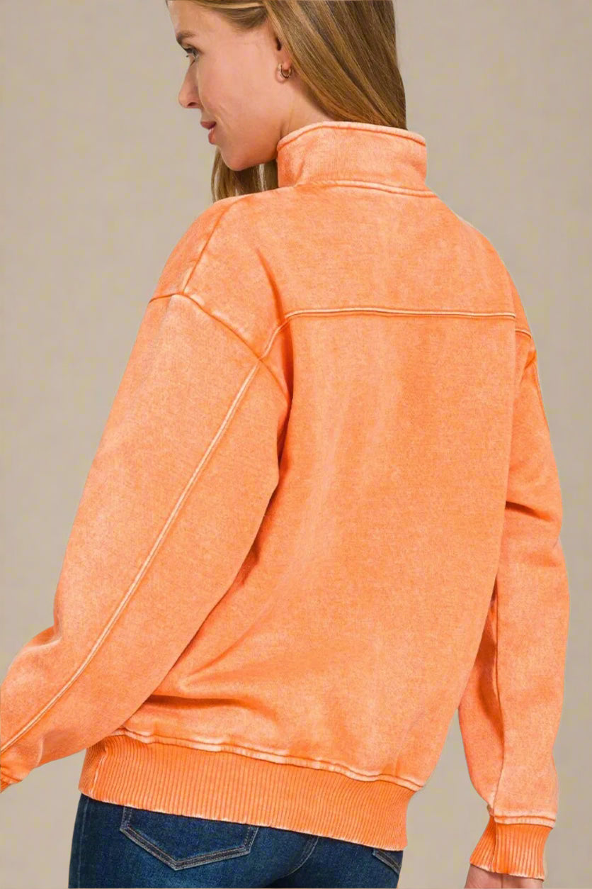 Person wearing an orange jacket on a beige background