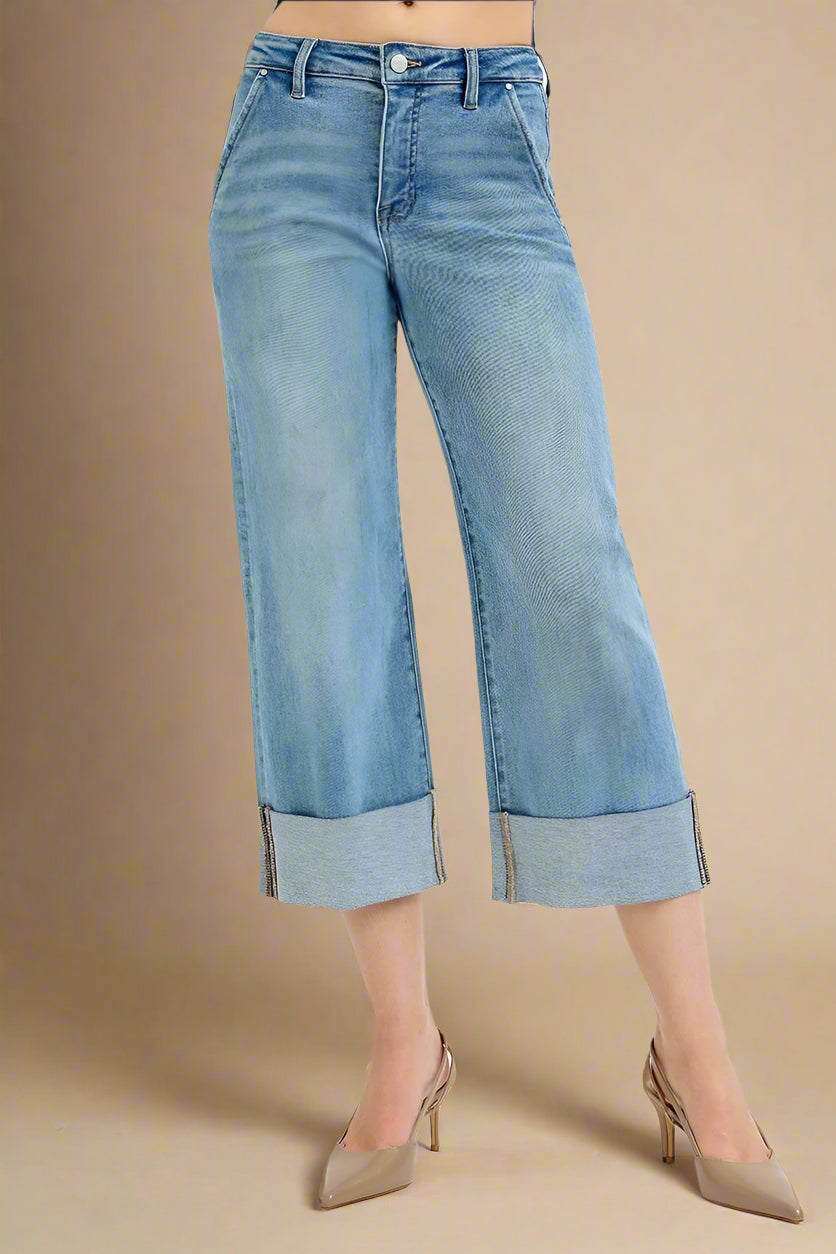Blue jeans with rolled-up cuffs on a white background