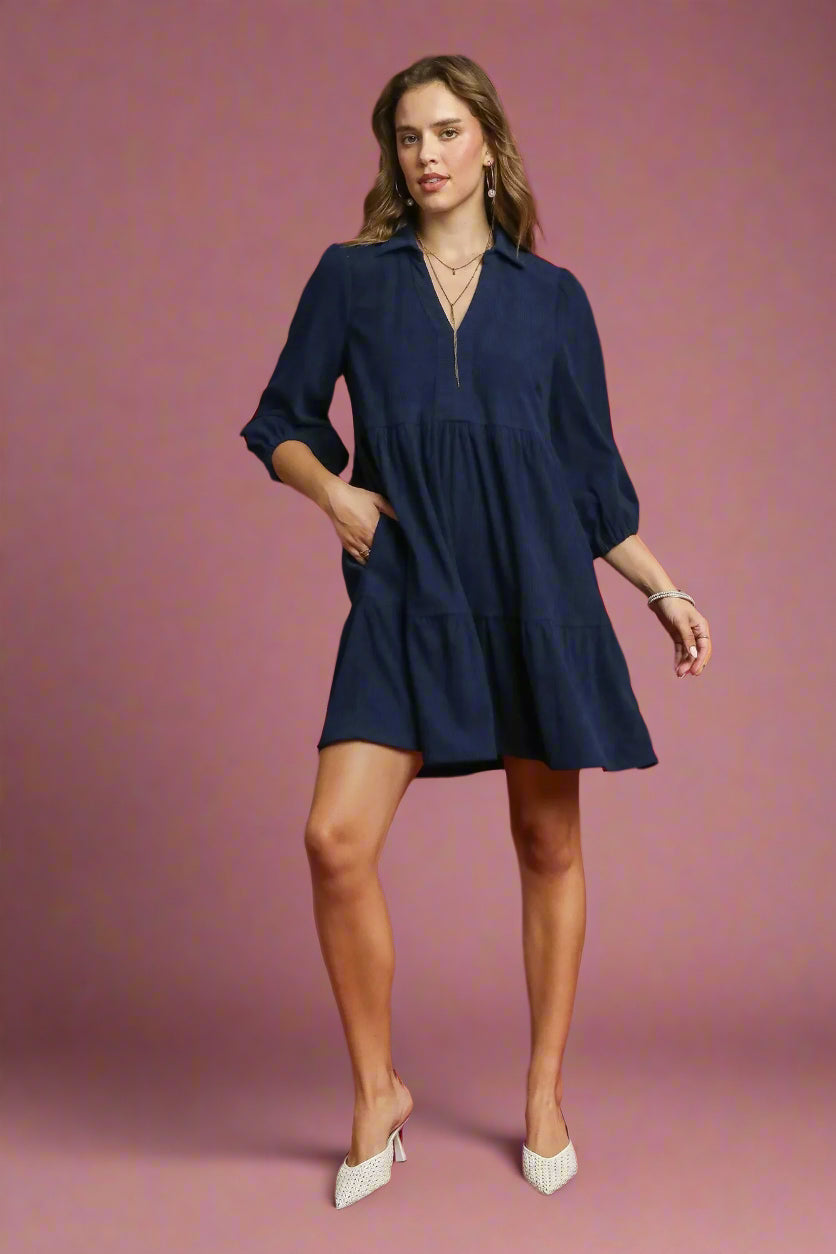 Woman wearing a navy dress on a red background