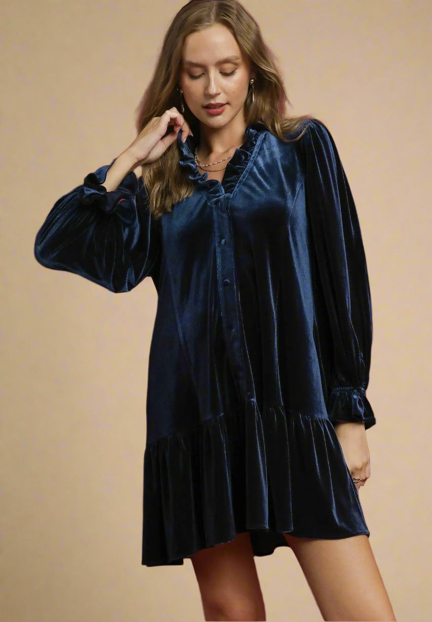 Woman wearing a navy velvet dress against a beige background