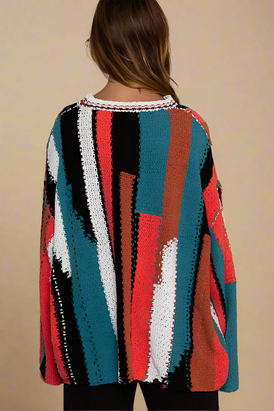 Multicolored striped sweater worn by a person against a light background