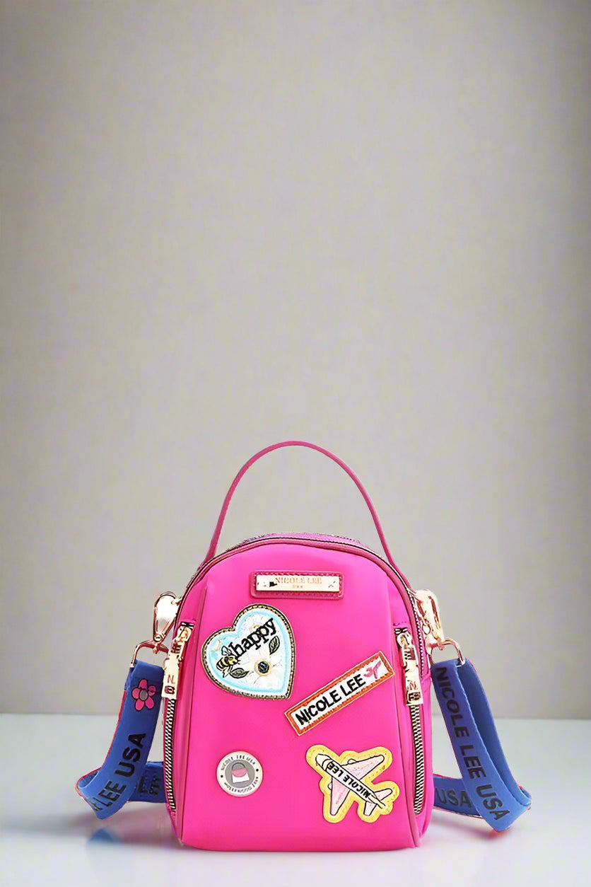 Pink backpack with colorful patches and blue straps on a white background