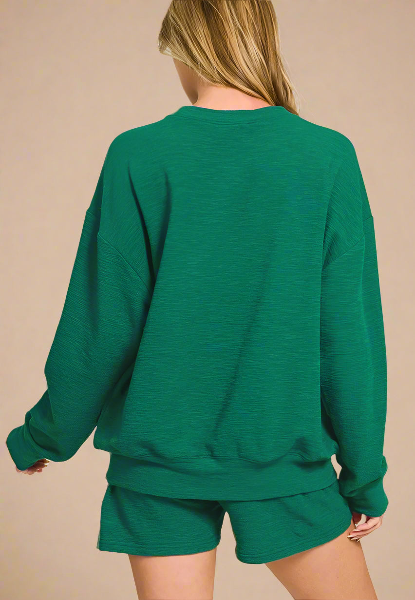 Green sweatshirt and shorts set on a white background