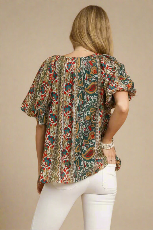 Woman wearing a patterned blouse with a beige background