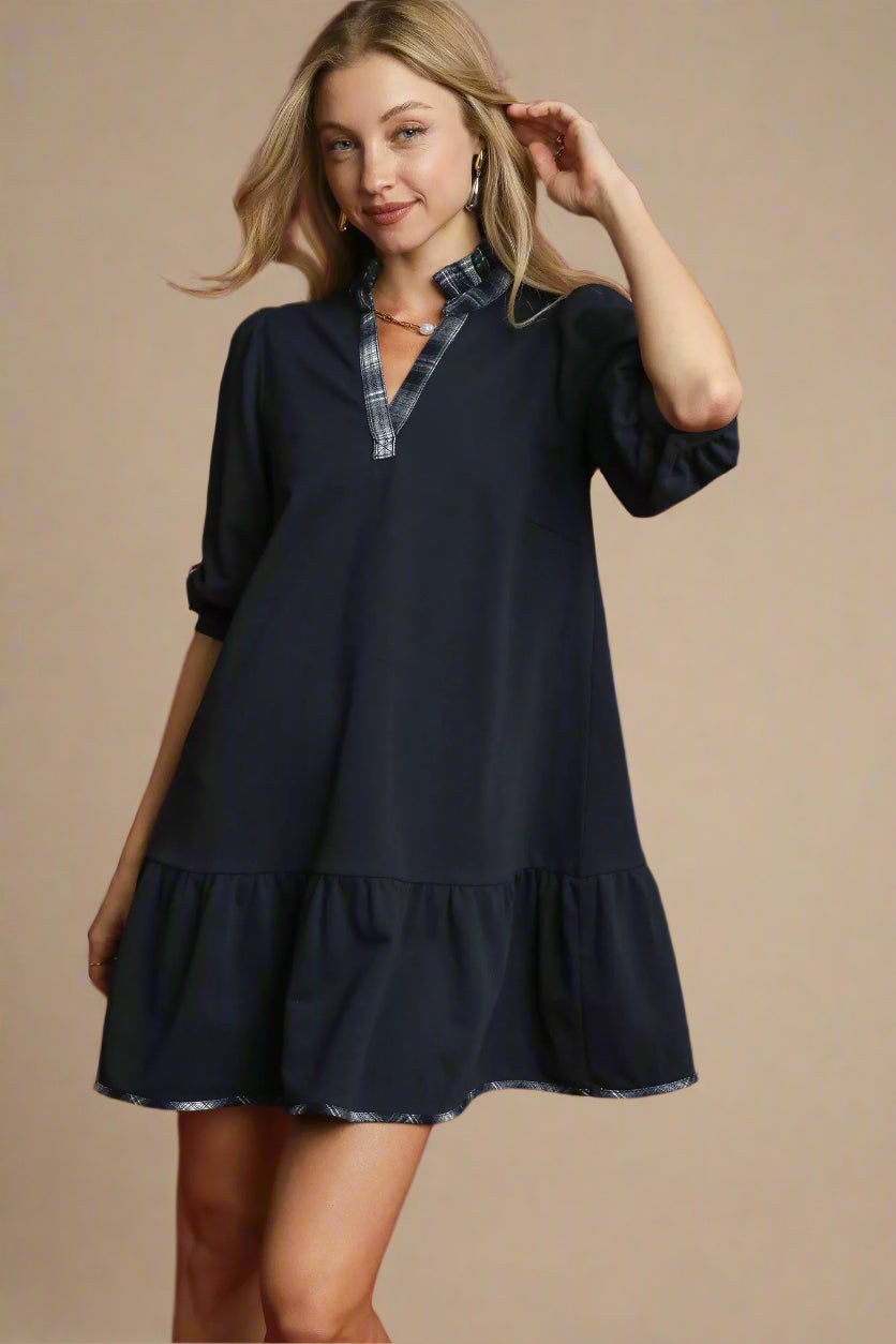 Woman wearing a navy dress with a red background