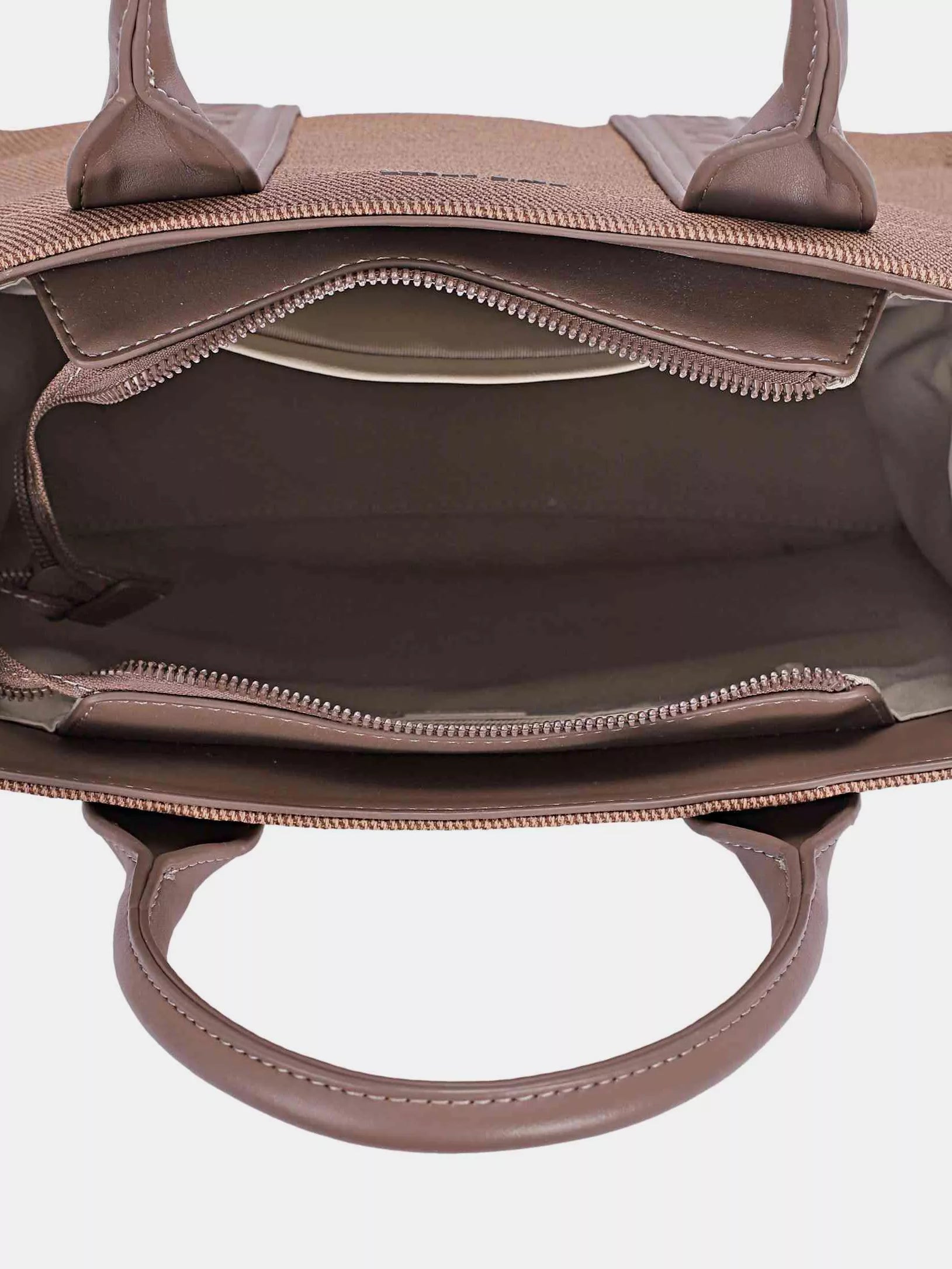 Close-up of a brown handbag with visible stitching on a white background