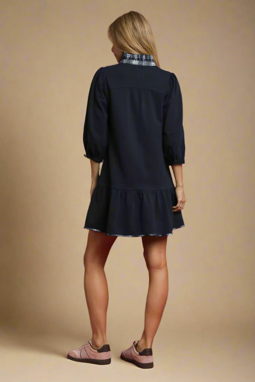 Woman wearing a navy dress on a red background