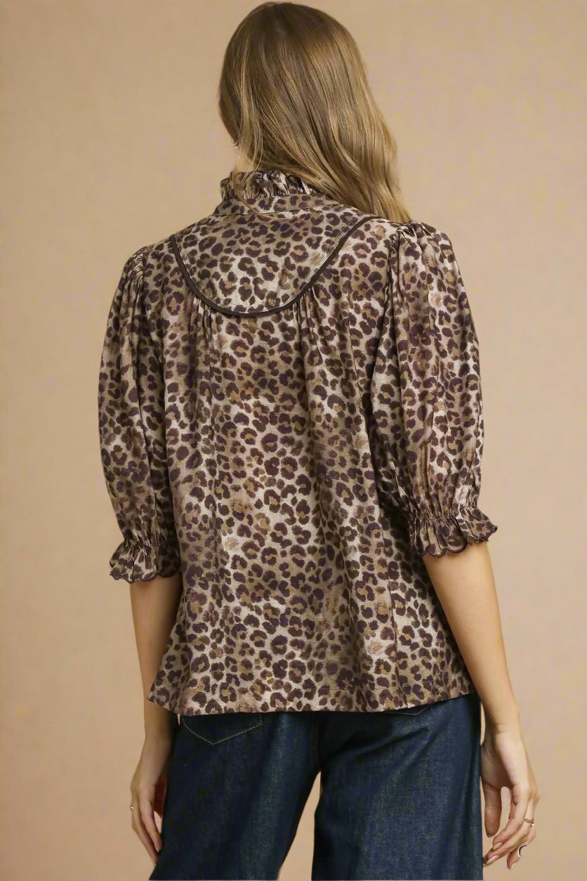 Woman wearing a leopard print blouse against a beige background