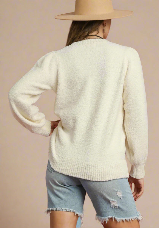 Person wearing a cream sweater and denim shorts with a beige hat on a red background