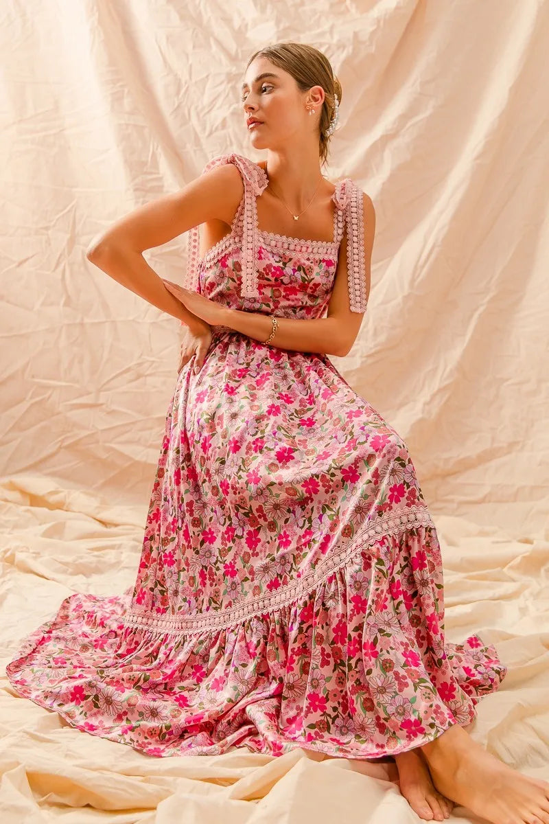 Woman wearing a pink floral dress against a beige background