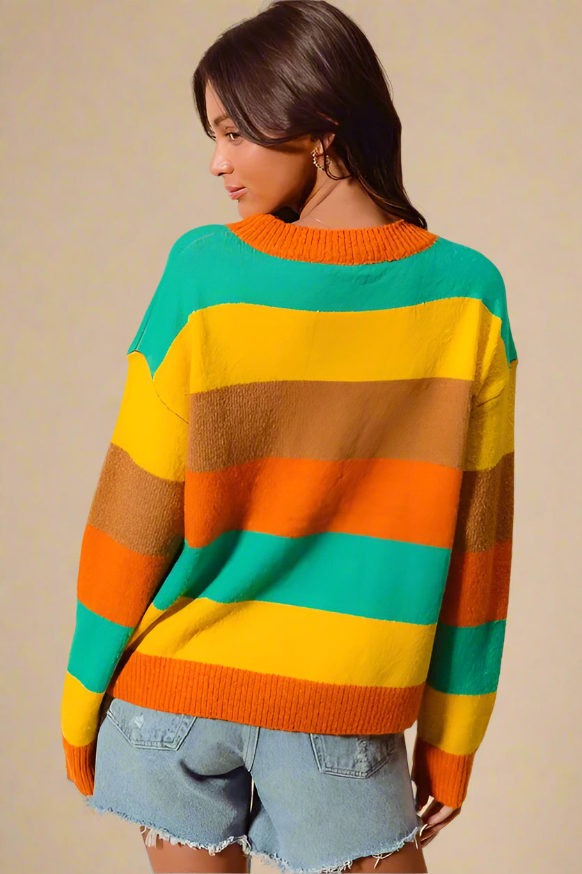 Person wearing a colorful striped sweater with a beige background