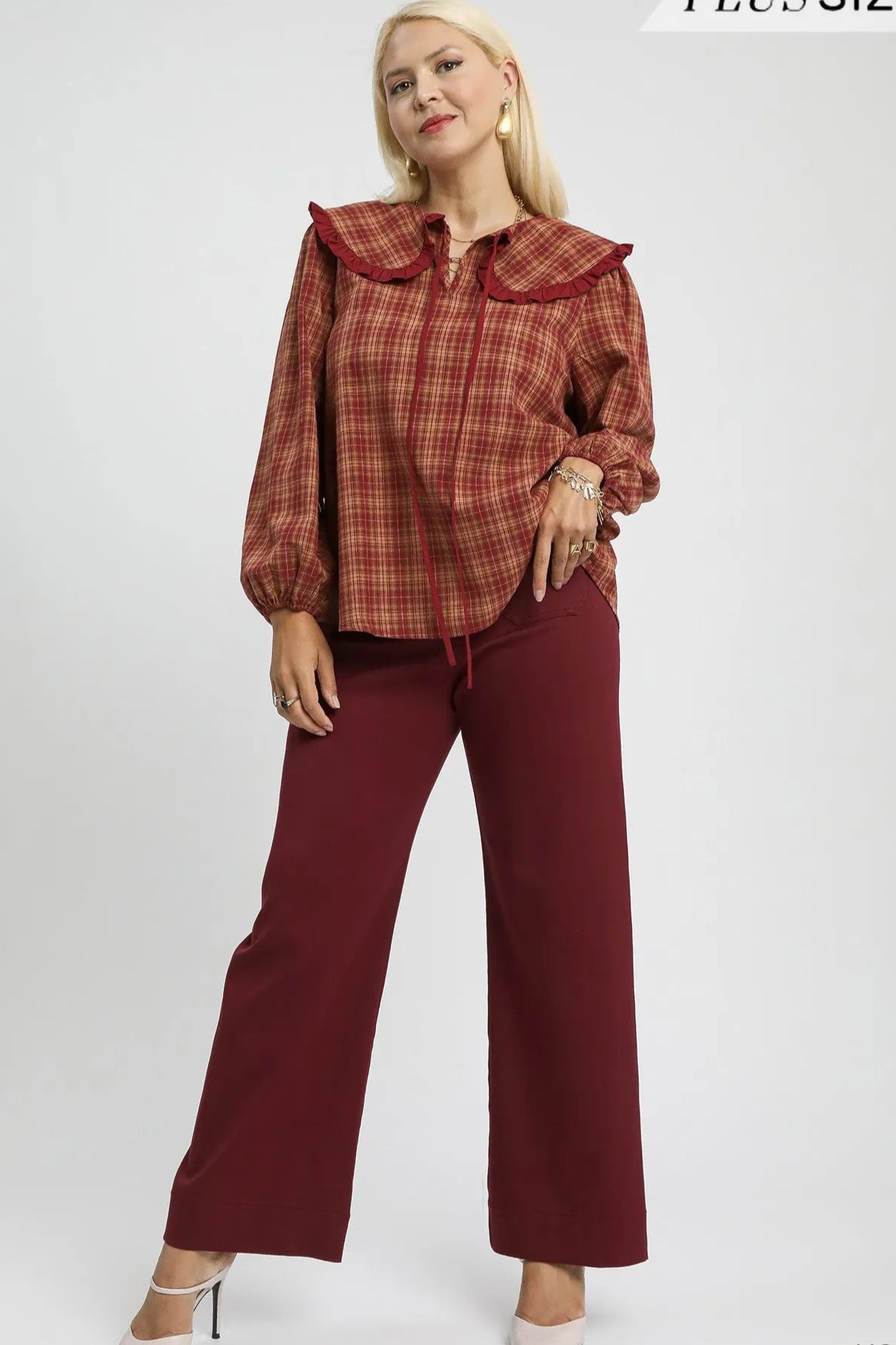 Woman wearing a rust-colored plaid blouse and pants with 'Plus Size' text above.