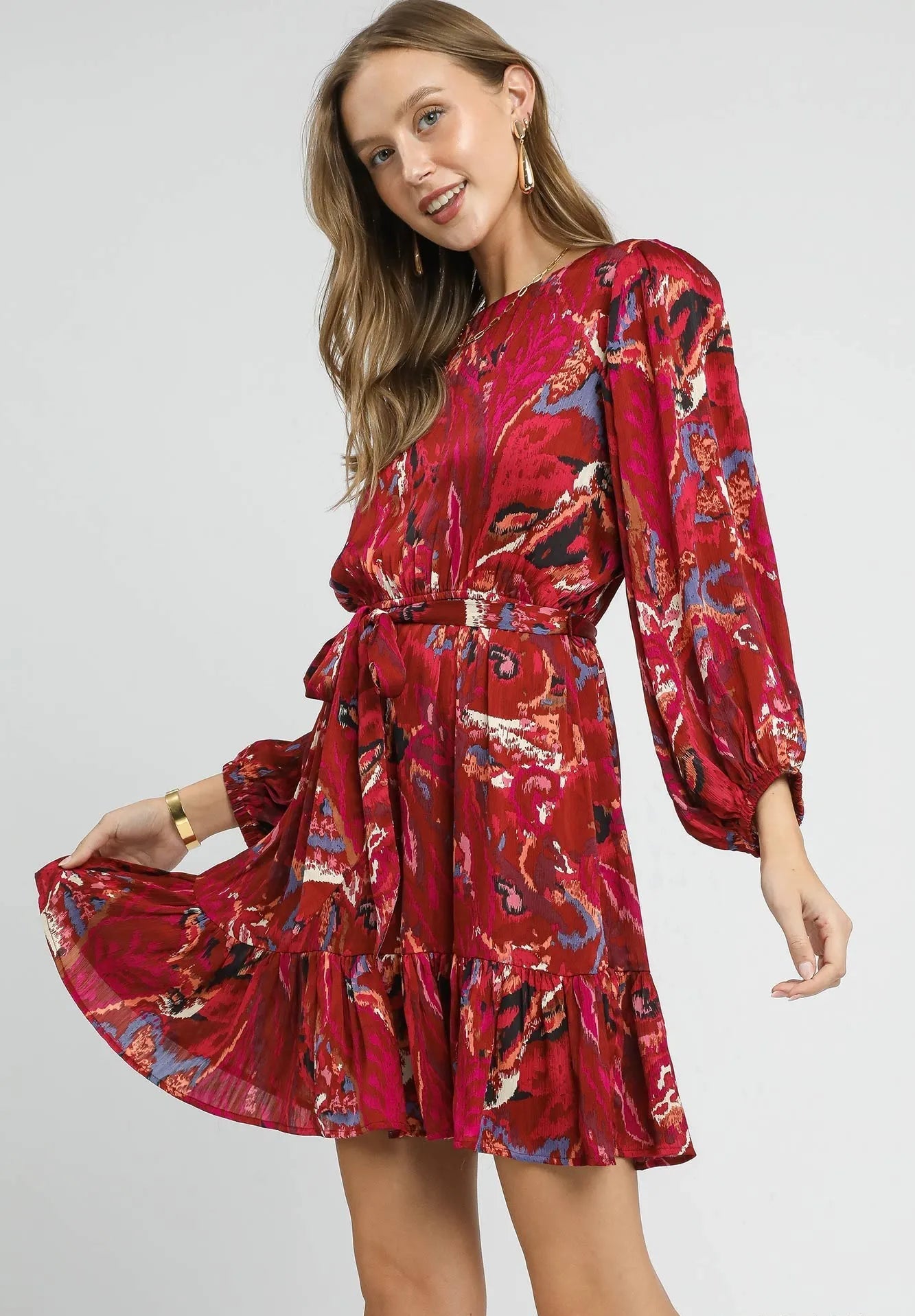 Woman wearing a red floral dress on a gray background